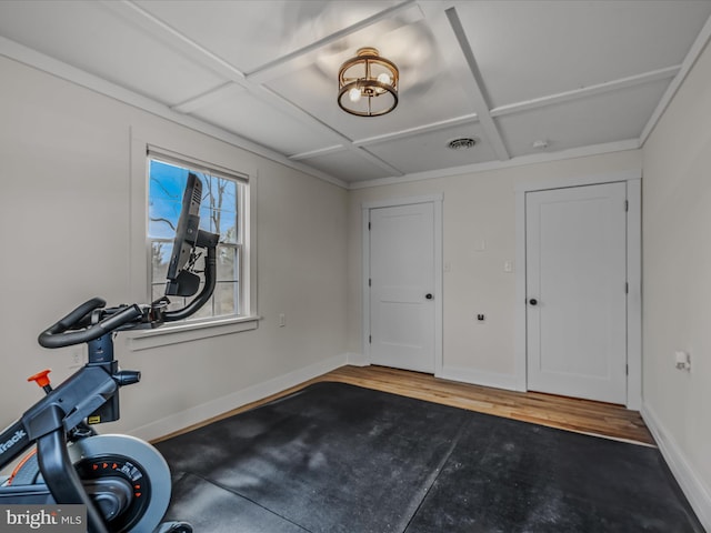 workout area featuring coffered ceiling, visible vents, baseboards, and wood finished floors