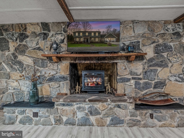 interior details with a textured ceiling, wood finished floors, and beam ceiling