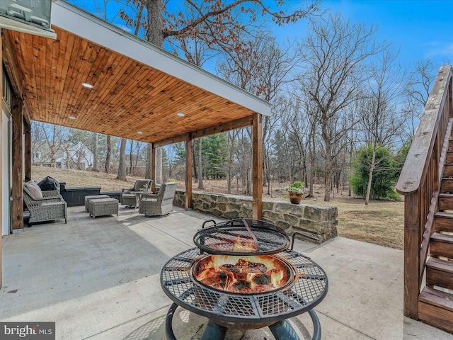 view of patio with an outdoor living space with a fire pit