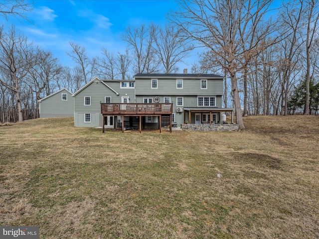 rear view of house featuring a lawn, a chimney, and a wooden deck