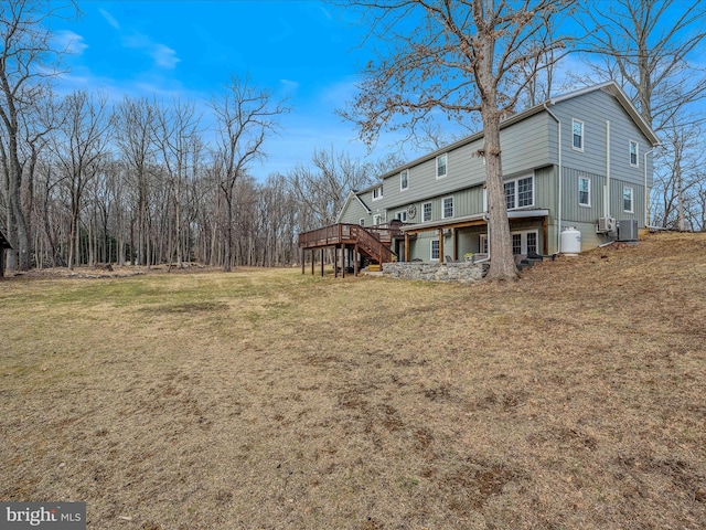 rear view of house featuring a deck, stairway, cooling unit, and a lawn