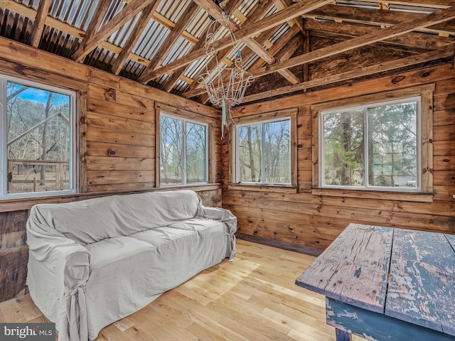 living room featuring lofted ceiling, hardwood / wood-style floors, and wood walls