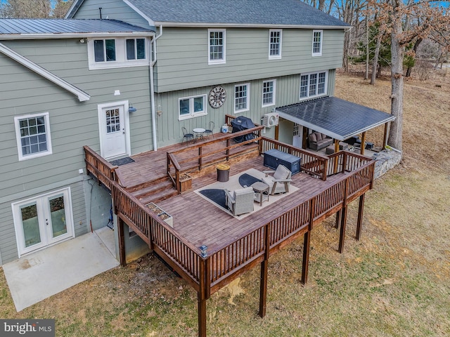 rear view of property featuring roof with shingles, metal roof, and a wooden deck