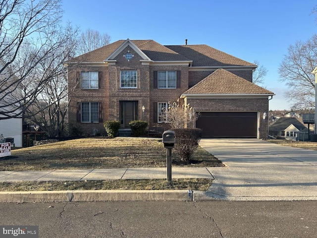 view of front facade featuring an attached garage, a shingled roof, concrete driveway, and brick siding