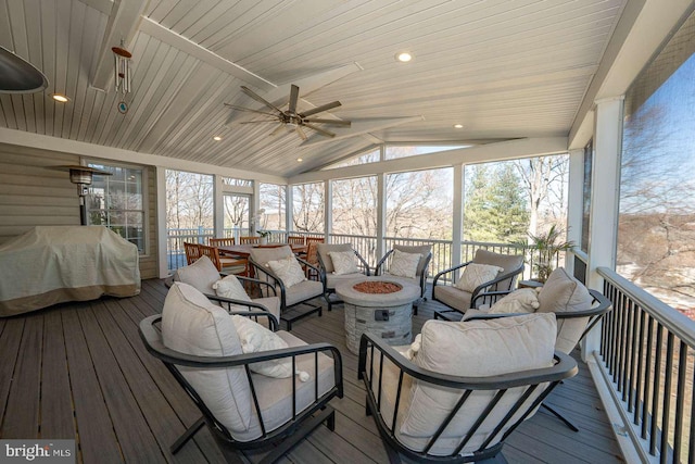 sunroom / solarium featuring lofted ceiling, plenty of natural light, wood ceiling, and a ceiling fan