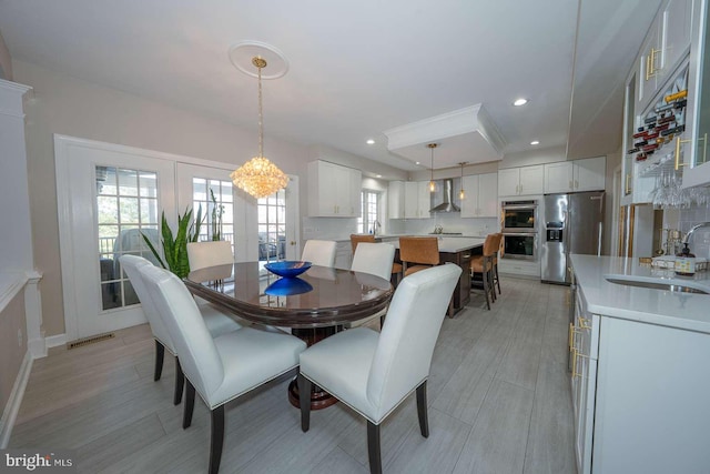 dining room featuring light wood-style floors, baseboards, visible vents, and recessed lighting