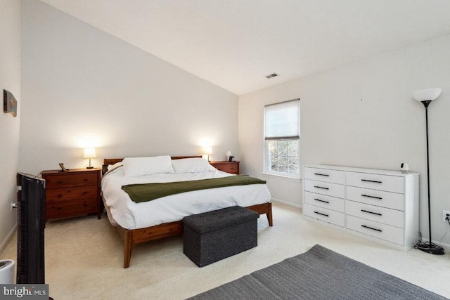 bedroom featuring visible vents, baseboards, light colored carpet, and vaulted ceiling