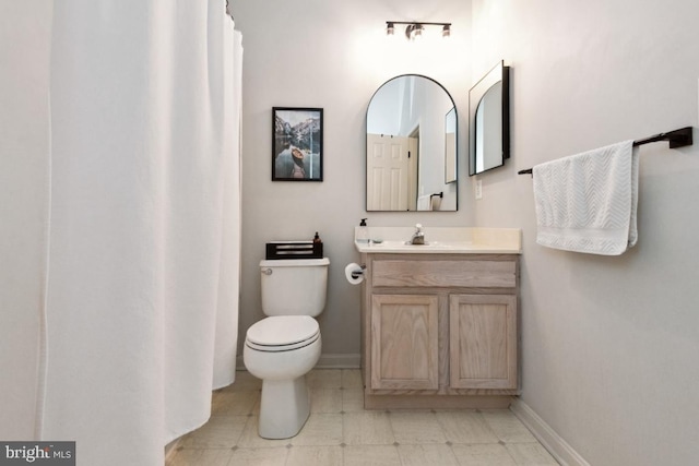 full bathroom with vanity, toilet, and baseboards