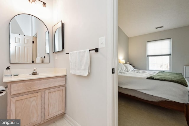 ensuite bathroom featuring visible vents, baseboards, vanity, and ensuite bathroom