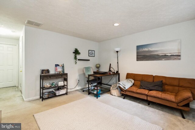 carpeted living area with visible vents, recessed lighting, a textured ceiling, and baseboards