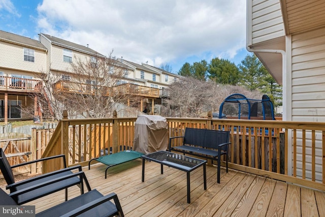 wooden terrace with a residential view and a grill