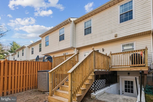 rear view of property featuring a deck, stairway, fence, and central AC