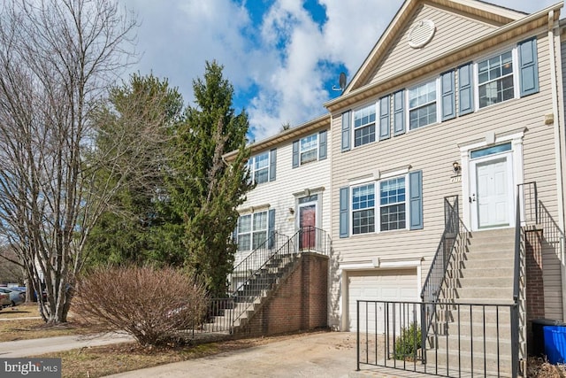 townhome / multi-family property featuring stairway, concrete driveway, and an attached garage