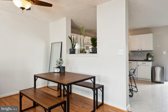 dining area featuring baseboards, a ceiling fan, and light wood finished floors