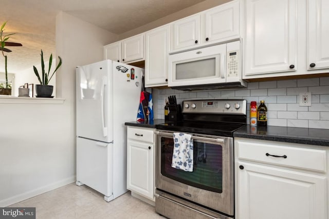 kitchen with decorative backsplash, white appliances, dark countertops, and white cabinets