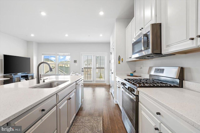 kitchen with a sink, recessed lighting, appliances with stainless steel finishes, white cabinets, and dark wood-style flooring