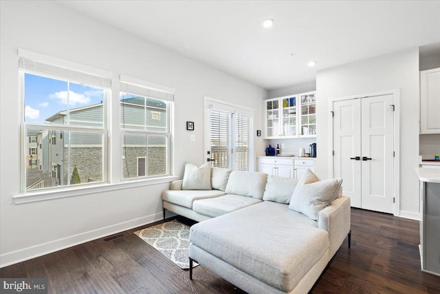 living area with recessed lighting, visible vents, baseboards, and dark wood-style flooring