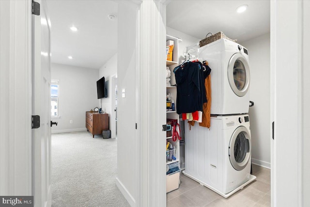 laundry area featuring baseboards, laundry area, recessed lighting, stacked washer / drying machine, and light carpet