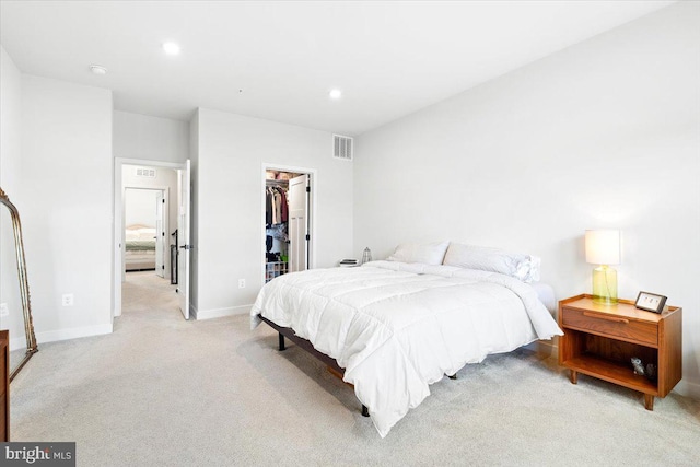 carpeted bedroom featuring visible vents, baseboards, recessed lighting, a closet, and a walk in closet