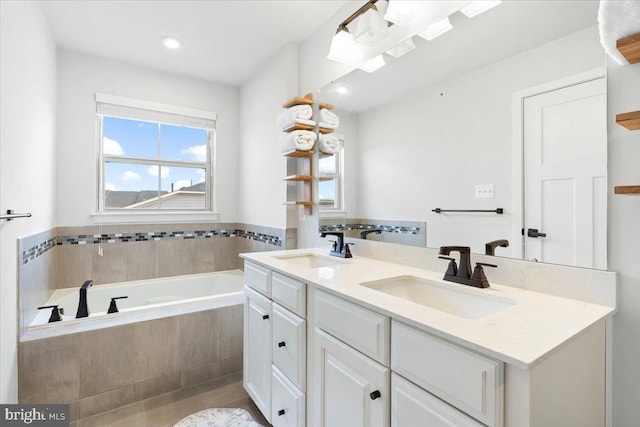 bathroom with a bath, tile patterned flooring, double vanity, and a sink