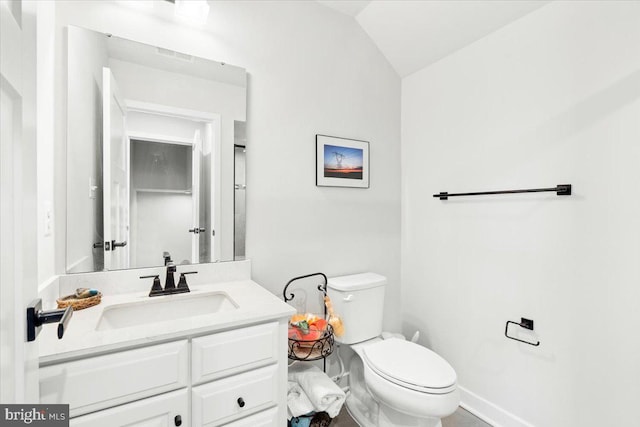 bathroom featuring visible vents, baseboards, toilet, vaulted ceiling, and vanity