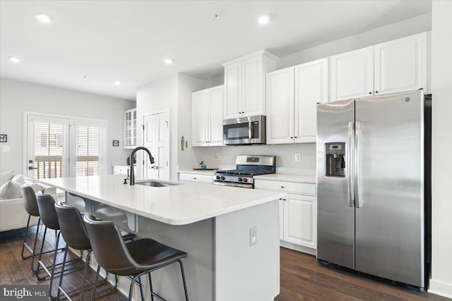 kitchen featuring dark wood-style floors, white cabinets, appliances with stainless steel finishes, and a sink