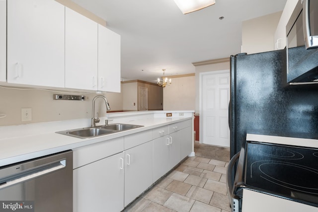 kitchen featuring stainless steel appliances, light countertops, white cabinetry, a sink, and a peninsula