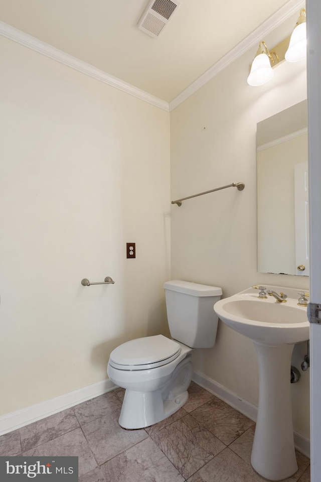 bathroom featuring toilet, baseboards, visible vents, and ornamental molding