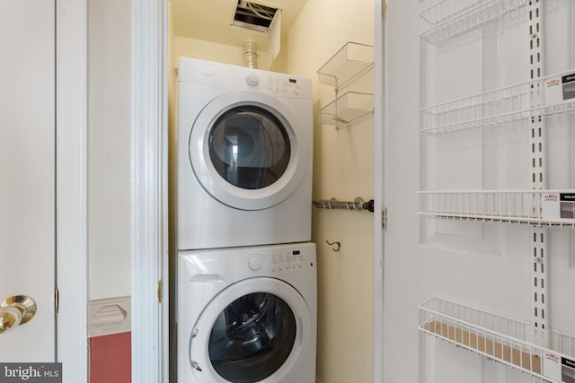 clothes washing area featuring laundry area and stacked washing maching and dryer