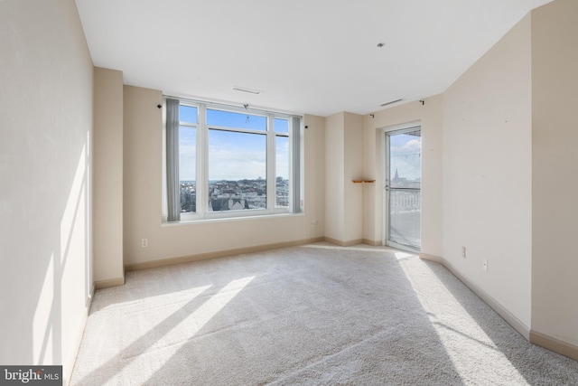 unfurnished room featuring light carpet and baseboards