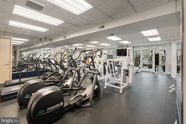 exercise room with a paneled ceiling and visible vents