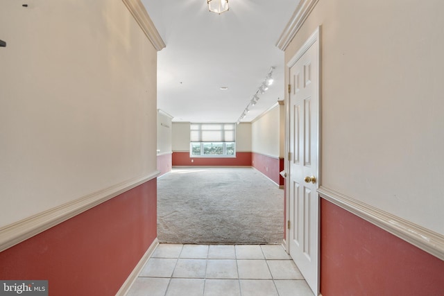 hall featuring rail lighting, a wainscoted wall, light carpet, and light tile patterned floors