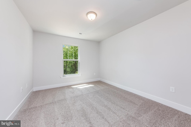 empty room featuring carpet flooring and baseboards