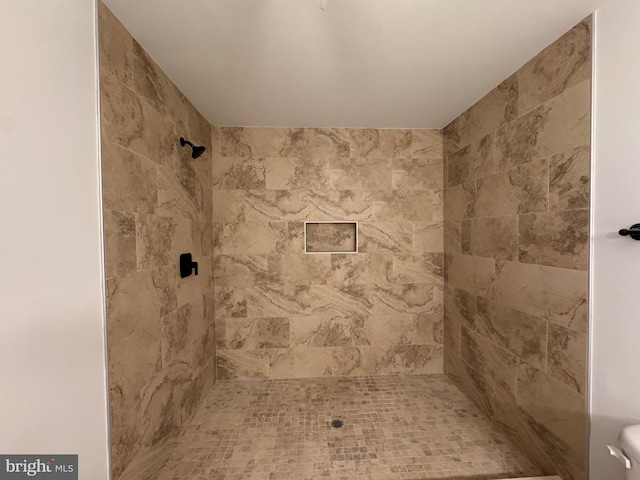 bathroom with toilet and tiled shower