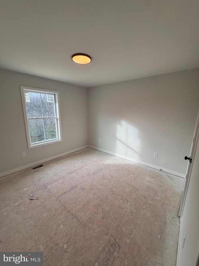 spare room featuring baseboards and visible vents