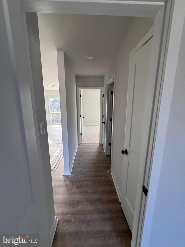 corridor featuring dark wood-style floors and baseboards