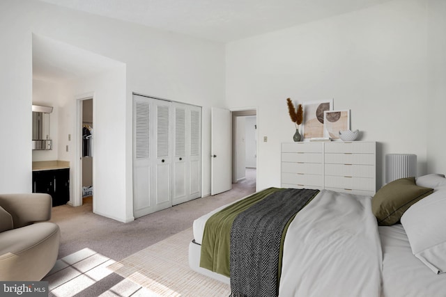 carpeted bedroom featuring a closet and ensuite bath