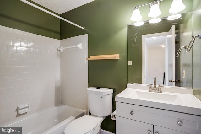 bathroom featuring a textured ceiling, bathing tub / shower combination, vanity, and toilet