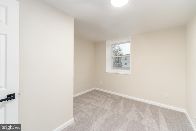 carpeted empty room featuring baseboards