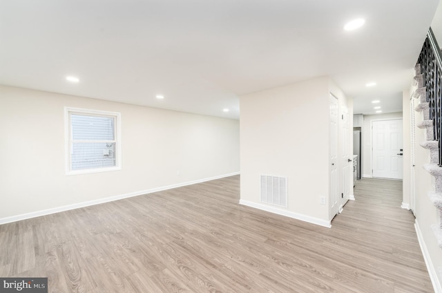 basement featuring baseboards, visible vents, and light wood-style floors