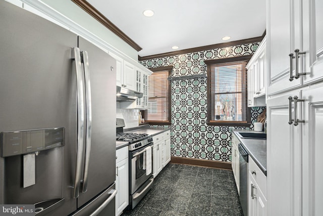 kitchen featuring granite finish floor, appliances with stainless steel finishes, under cabinet range hood, baseboards, and wallpapered walls