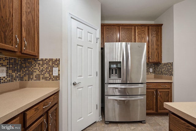 kitchen featuring tasteful backsplash, light countertops, and stainless steel fridge with ice dispenser