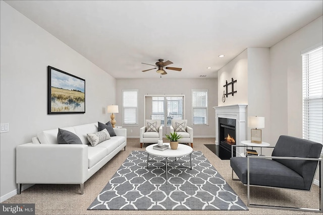 living area featuring carpet, a fireplace with flush hearth, and baseboards