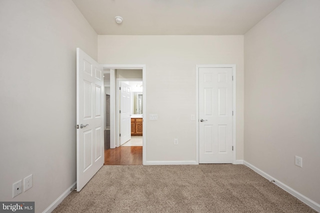 unfurnished bedroom featuring carpet flooring and baseboards