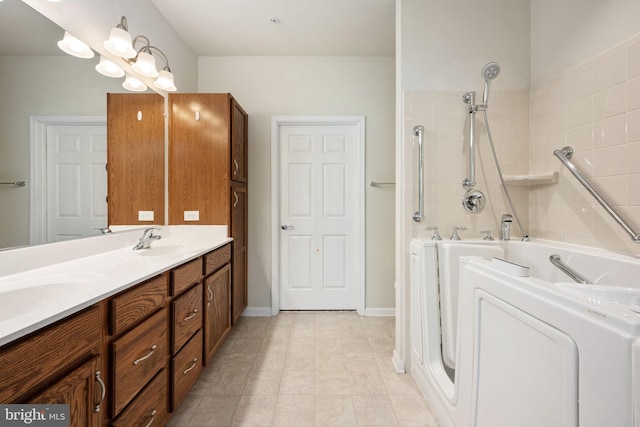 full bathroom featuring a sink, double vanity, washer / clothes dryer, and a tile shower