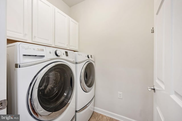 laundry room featuring baseboards, cabinet space, and washing machine and clothes dryer