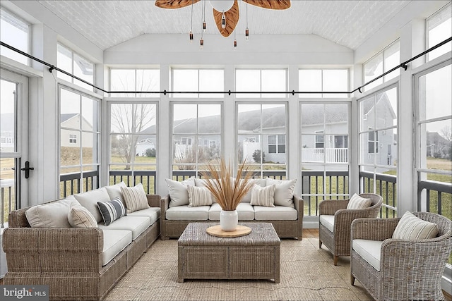 sunroom with vaulted ceiling and a ceiling fan