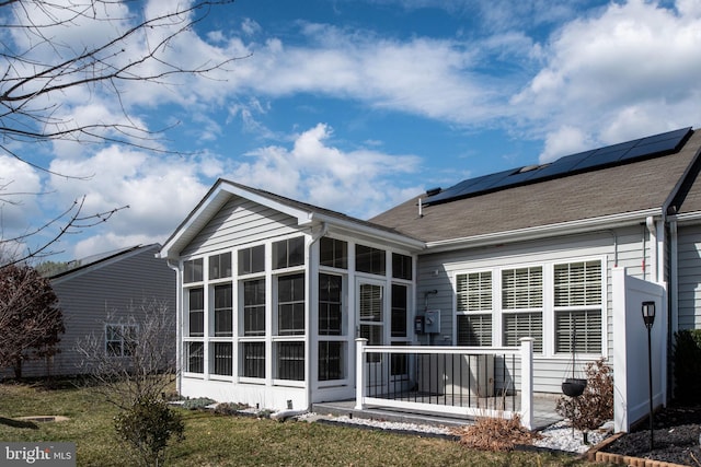 back of property featuring solar panels and a sunroom