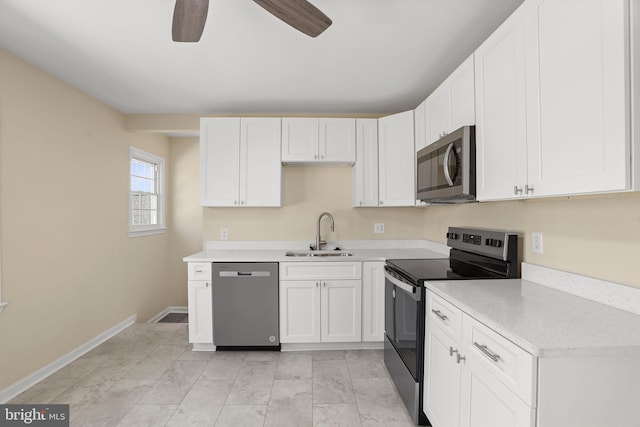 kitchen with baseboards, a sink, stainless steel appliances, light countertops, and white cabinets