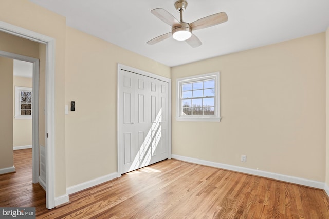 unfurnished bedroom featuring light wood finished floors, a closet, and baseboards